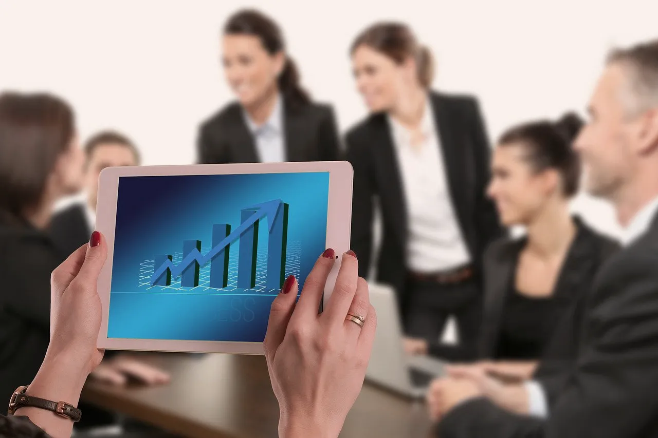 A marketing professional reviews law firm growth data on a tablet during a business meeting, representing measurable SEO results and business impact achieved by SnowdriftCO.