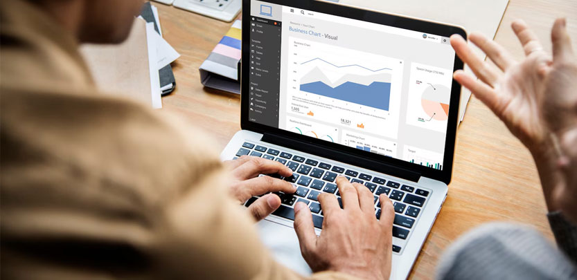 Hands typing on a laptop displaying a business analytics chart during a strategy session